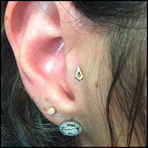 Tragus piercing with gold top