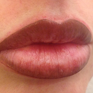 Micropigmentación de labios con sombreado de color terracota oscuro.